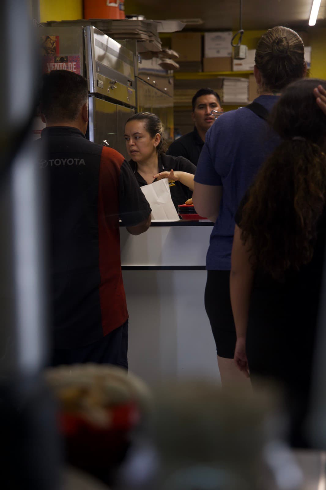 Equipo atendiendo a clientes en el mostrador con dedicación